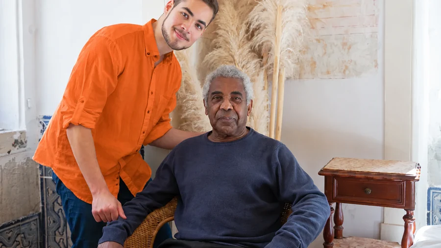 Betreuungskraft unterstützt eine ältere Person einfühlsam zu Hause