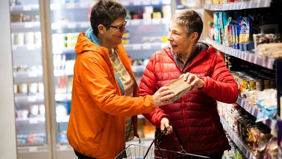 Zwei ältere Menschen kaufen gemeinsam im Supermarkt ein